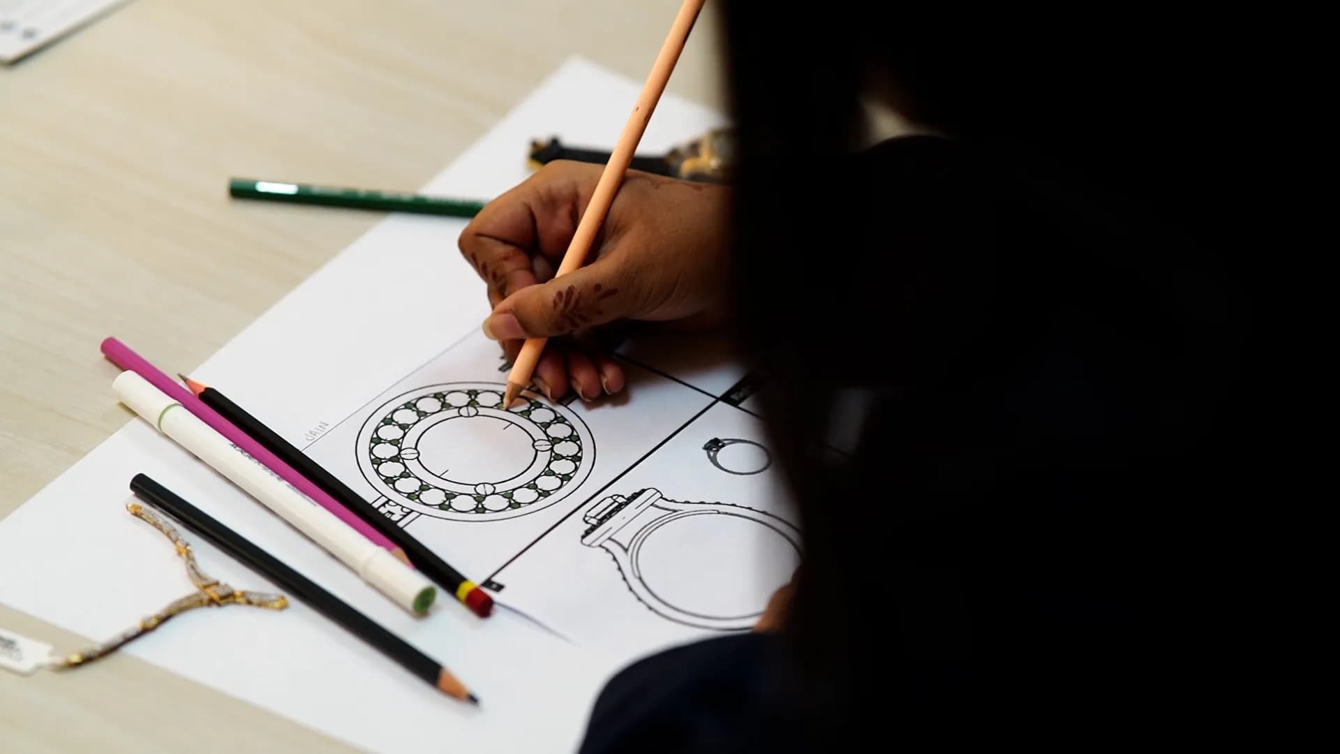 Close-up of a student pencil-sketching a ring design