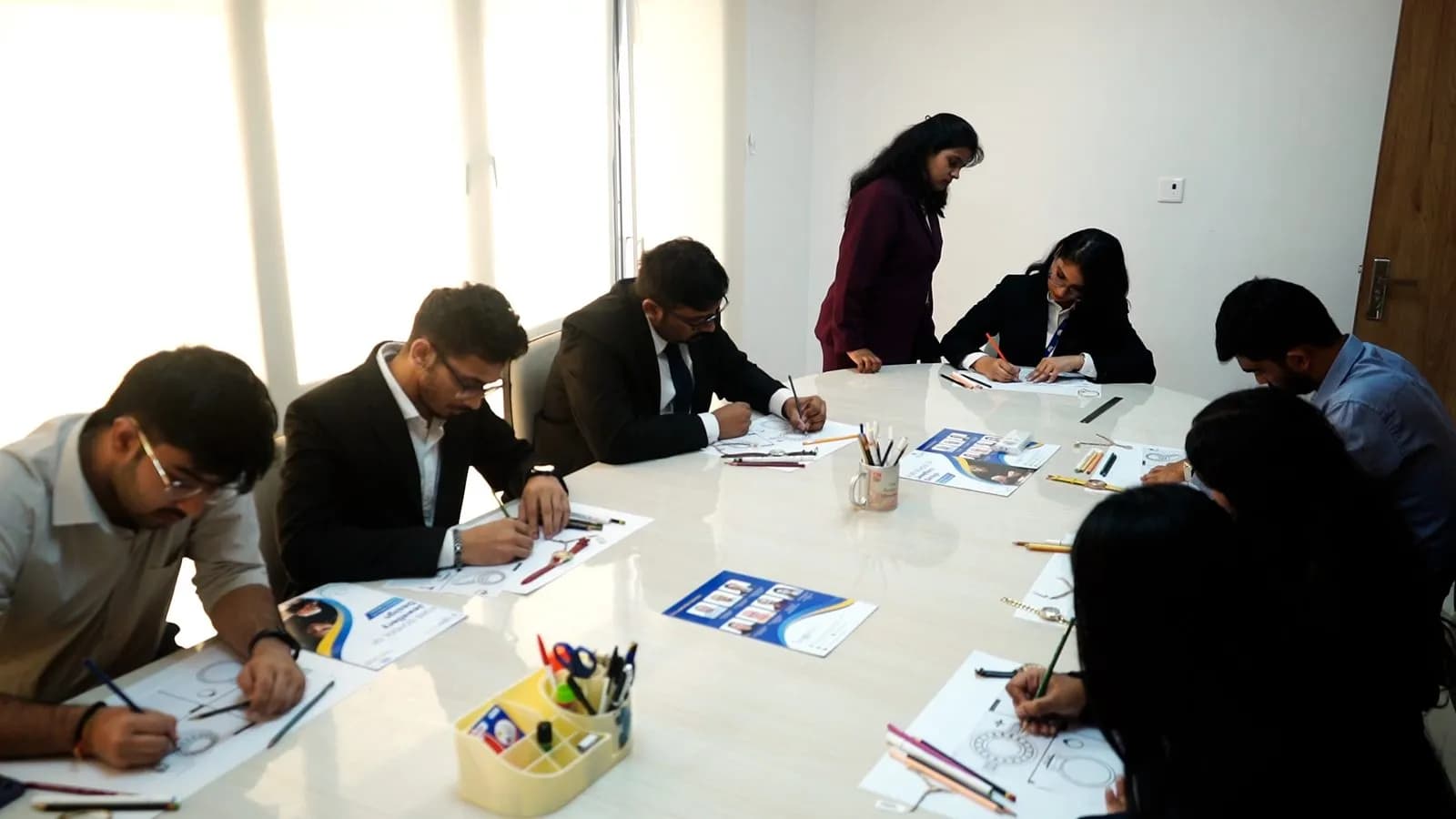 Students sketching jewellery designs by hand in a studio session
