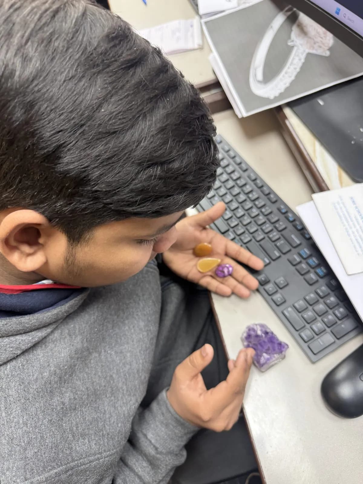 A student studying loose gemstones — citrine and amethyst